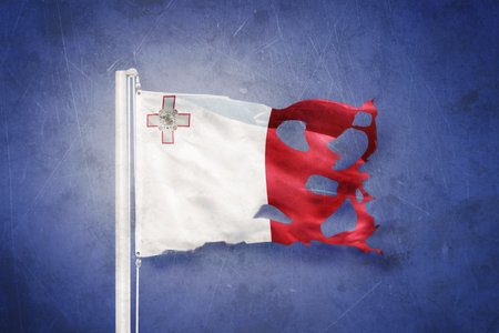 Torn flag of Malta flying against grunge backgroundの写真素材