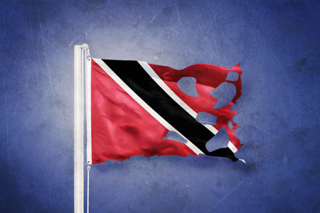 Torn flag of Trinidad and Tobago flying against grunge backgroundの写真素材