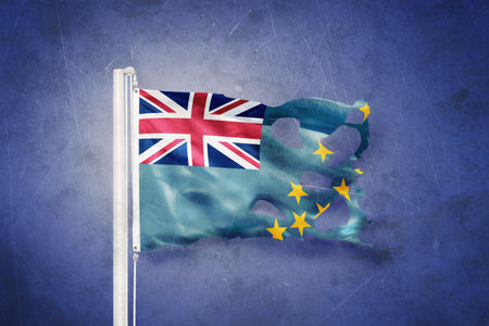 Torn flag of Tuvalu flying against grunge backgroundの写真素材