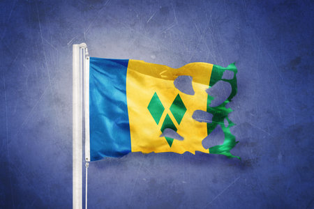 Torn flag of Saint Vincent and the Grenadines flying against grunge backgroundの写真素材