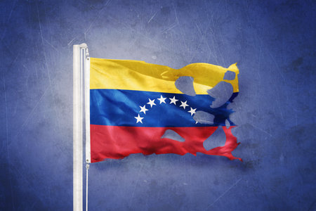 Torn flag of Venezuela flying against grunge backgroundの写真素材