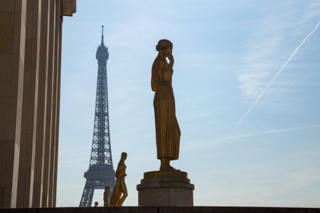 Paris, France, March 27 2017: Golden bronze statues in the Trocadero garden, Eiffel tower in the backgroundのeditorial素材