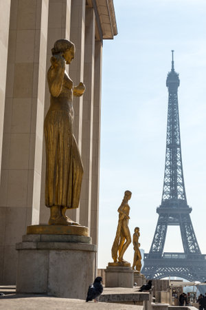 Paris, France, March 27 2017: Golden bronze statues in the Trocadero garden, Eiffel tower in the backgroundのeditorial素材