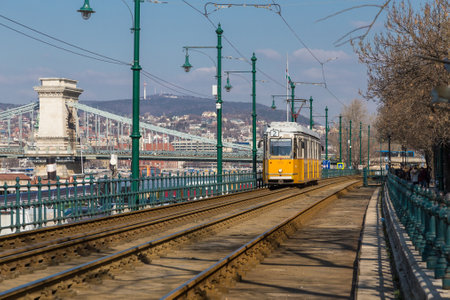 Budapest, Hungary, March 22 2018: Yellow Tram in early winter with cloudy sky. Tram number 2 is famous for being the best european line selected by National Geographicのeditorial素材