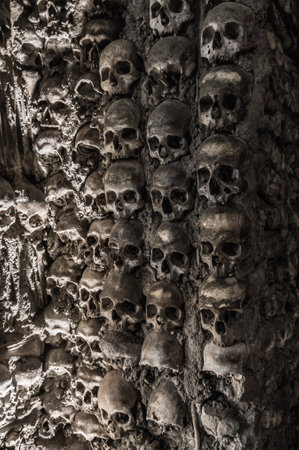 Human skulls and bones at a wall in the bone chapel Evoraの写真素材