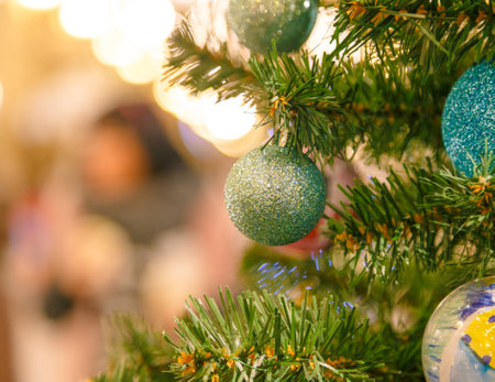 Decorated Christmas tree on blurred background. Close up of baubles and branch at New Year fir treeの写真素材