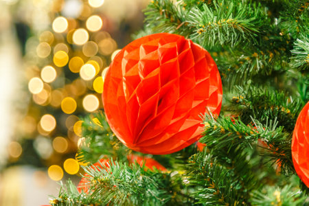 Close-up view of shiny red bauble on christmas tree.の写真素材