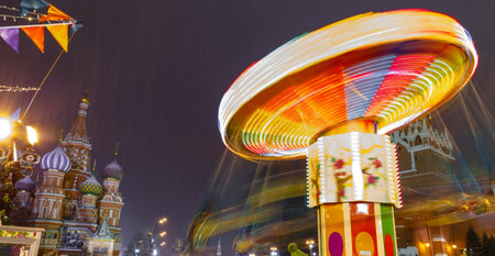 Moscow, Russia, December 5, 2017: People on Christmas market on Red Square in Moscow city center, Decorated and illuminated Red Square for Christmas in Moscow. Carousel swings on Christmas bazaarのeditorial素材