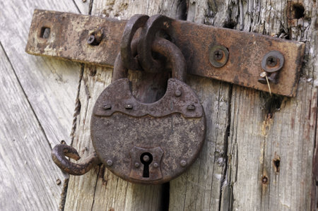 Old rusted lock on a rustic door with decorative natural weathered wood planksの写真素材