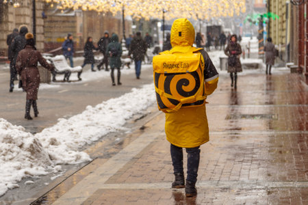MOSCOW, RUSSIA - FEBRUARY 13,2019: A man from the delivery service of food - Yandex Eda, on the streets of city.food deliveryのeditorial素材