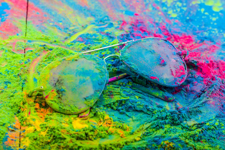 Holi color powder on sunglasses. Organic Gulal colours on eyeglasses for Holi festival, Hindu tradition festive.の写真素材