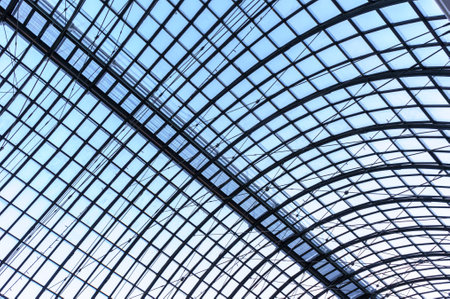 Under the roof. Glass panel roof with white battens under bright blue sky.の写真素材
