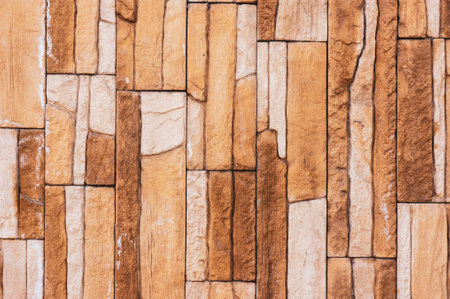 Rock stone brick tile wall has a detailed background texture sepia cream brown color stacked in...