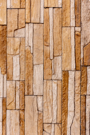 Rock stone brick tile wall has a detailed background texture sepia cream brown color stacked in...