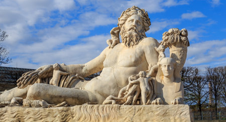 Paris, France - March 28, 2017: A statue of the Colossus Nile in the Jardin des Tuileries in Paris against a bright blue sky with white clouds, Franceのeditorial素材
