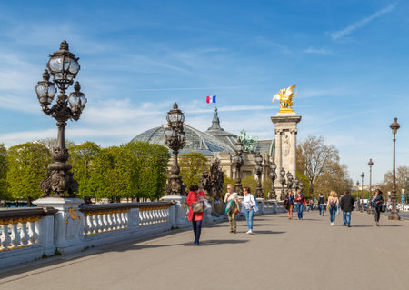 Paris, France, March 31, 2017: Pont Alexandre III in Paris, spanning the river Seine. Decorated with ornate Art Nouveau lamps and sculptures. The most ornate, extravagant bridge in Parisのeditorial素材