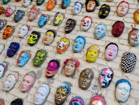 Moscow, Russia, 21 October 2019: Colorful painted ceramic faces sculpture on the bricks wall as an the object of modern art. Hundred faces by Marat Nabi. Bricks wall with decorative elementのeditorial素材