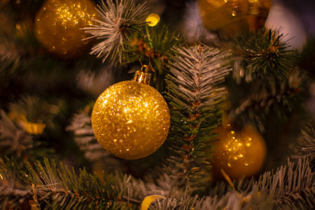 Christmas tree with silver bauble ornaments. Decorated Christmas tree closeup. Balls and illuminated garland with flashlights. New Year baubles macro photo with bokeh. Winter holiday light decorationの写真素材