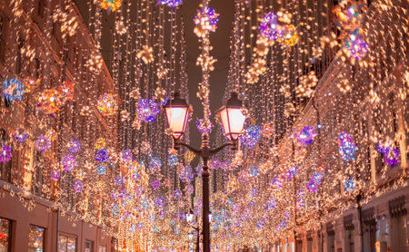 Moscow, Russia - November 27, 2019: Golden colorful rain of Christmas decorations hanging from the sky, on Nikolskaya street next to GUM in the capital. Nikolskaya street illuminated. Beautiful lightsのeditorial素材