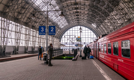 Moscow, Russia - March 23, 2013: Covered platform of Kievsky railway station. Red train aeroexpress to airport. People on the platform beside the Aero express train at Kievsky railway station Moscowのeditorial素材
