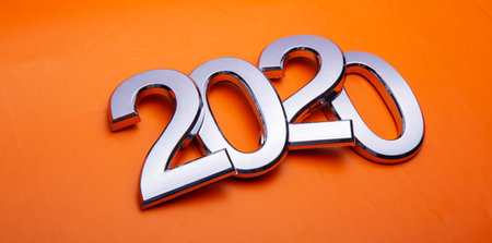 Happy New Year 2020. Symbol from number 2020 on orange background. Silver letters in the form of numbers 2020.の写真素材