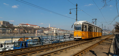Budapest, Hungary, March 22 2018: Yellow Tram in early winter with cloudy sky. Tram number 2 is...