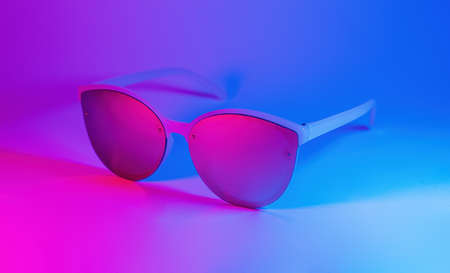 Sunglasses in vibrant bold gradient purple and blue holographic colors. Concept art. Minimal summer surrealismの写真素材