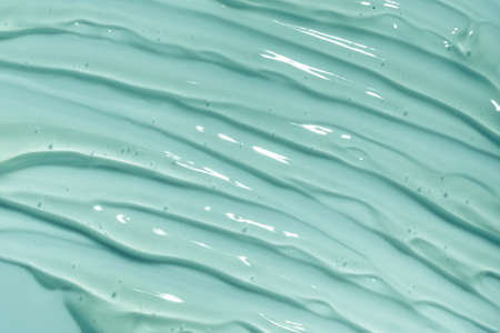 Blue gel texture. Hand sanitizer, alcohol gel background. Cosmetic clear liquid cream smudge. Transparent skin care product sample closeupの写真素材