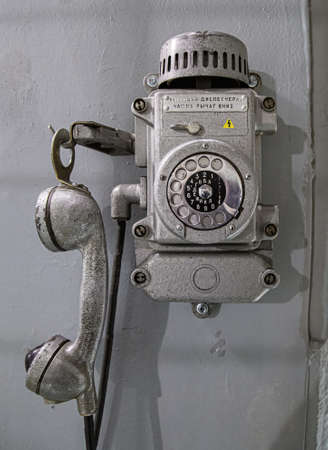 Old metal wall-mounted telephone with rotary dial. Antique phone with dialの写真素材