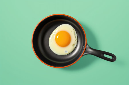 Creative food concept with fried egg on pan over yellow background. Top view. Creative pattern in minimal style. Flat lay. Square crop.の素材