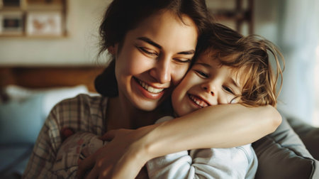 Portrait of beautiful young mother cuddling with teen son at home.の素材