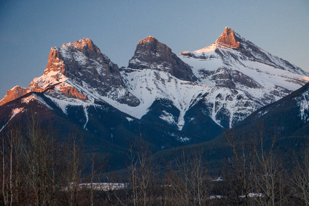 Early spring time in Canmore, snowy mountains, winter atmosphere, icy cold, symbols of town of Canmore, Canada, Three sisters peaks, canadian hiking, canadian natureの写真素材