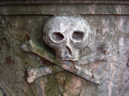 Skull and crossbones carving on a cemetery wallの写真素材