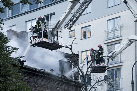 WARSAW, POLAND - AUGUST 30, 2015: Firefighters in action with water to put out the fire in Warsaw, Polandのeditorial素材