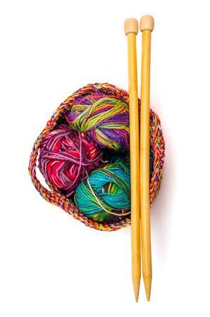 basket with colorful yarn and bamboo knitting needles