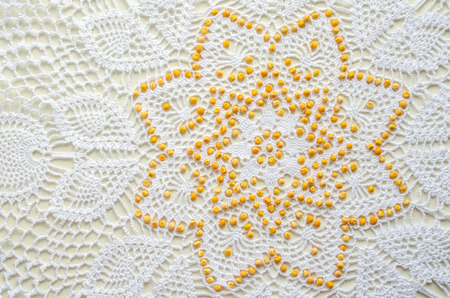 ornament peas laid out on the crocheted tableclothの写真素材