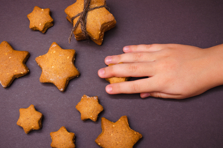 Child's hand take Christmas homemade gingerbread cookiesの写真素材