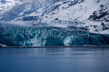 Bright blue icebergs float in calm waters by Mendenhall Glacier.の写真素材