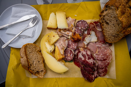 Indulging in a variety of meats and cheeses on a sunny afternoon.の写真素材
