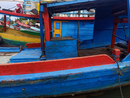 Fishing wooden boats anchored and leaned on the traditional harbour. Marine and maritime industry in Indonesia and Southeast Asiaの写真素材