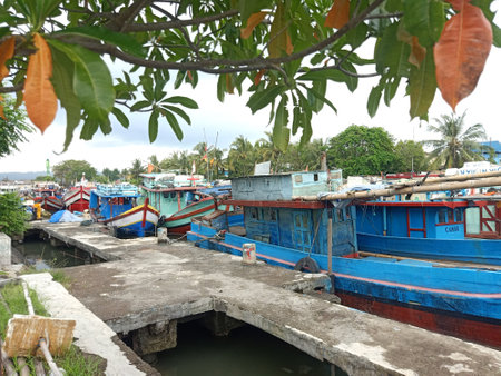 Fishing wooden boats anchored and leaned on the traditional harbour. Marine and maritime industry in Indonesia and Southeast Asiaの写真素材