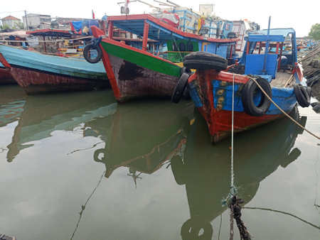 Fishing wooden boat rope mooring on the pier with blurry boat backgroundの写真素材