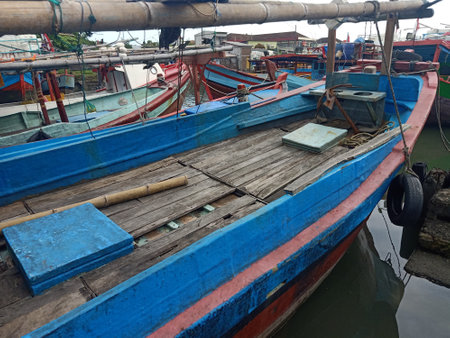 Fishing wooden boats anchored and leaned on the traditional harbour. Marine and maritime industry in Indonesia and Southeast Asiaの写真素材