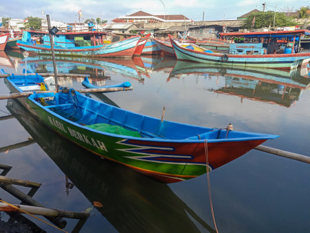 Fishing wooden boat is leaning in the harbor and anchored. Marine and maritime fisheries industry in Indonesia and Southeast Asiaの写真素材