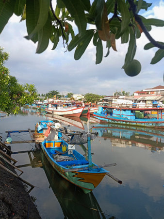 Fishing wooden boat is leaning in the harbor and anchored. Marine and maritime fisheries industry in Indonesia and Southeast Asiaの写真素材