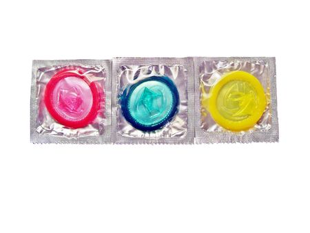 Condoms of different colors on a white surfaceの写真素材