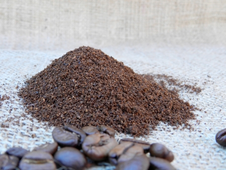 Ground coffee and coffee beans on old burlap backgroundの写真素材