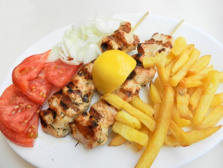 Souvlaki with onion,tomatoes and french friesの写真素材