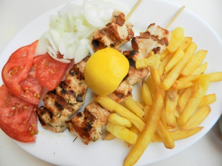 Souvlaki with onion,tomatoes and french friesの写真素材