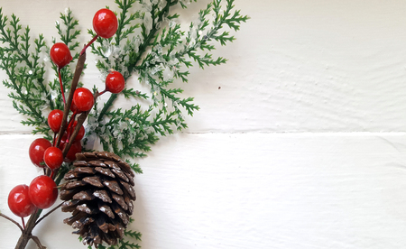 Christmas decoration  with fir branch,pine cone and berries on the white wooden boardの写真素材